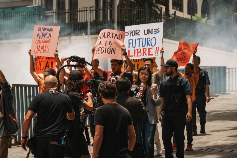 Journalists cover a protest rally for freedom in San José, Costa Rica. Demonstrators hold signs demanding liberty.
